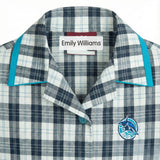 Close-up of a school uniform shirt collar with an iron-on name label showing the student name
